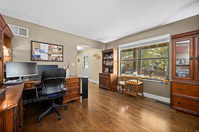 home office featuring a textured ceiling and dark hardwood / wood-style flooring