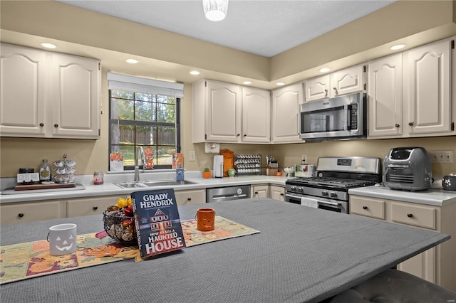 kitchen featuring white cabinets, appliances with stainless steel finishes, and sink