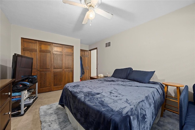 carpeted bedroom featuring ceiling fan, a textured ceiling, and a closet