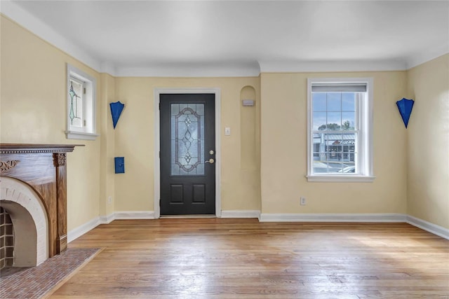 foyer entrance featuring light hardwood / wood-style flooring and a fireplace