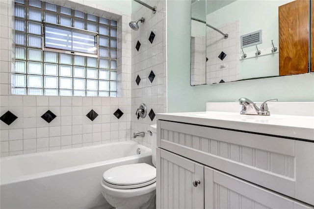 full bathroom with vanity, tiled shower / bath combo, and toilet