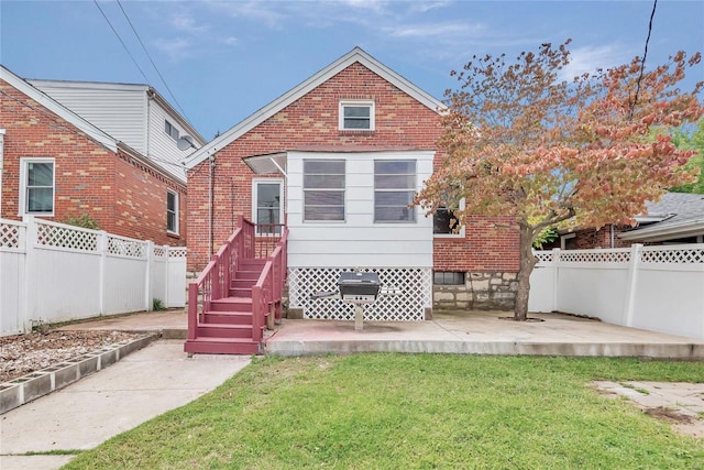 rear view of house featuring a patio area and a lawn