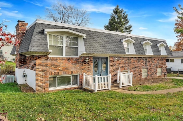 view of front of home featuring cooling unit and a front lawn