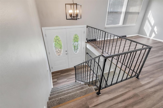 foyer entrance featuring hardwood / wood-style floors, an inviting chandelier, and a wealth of natural light