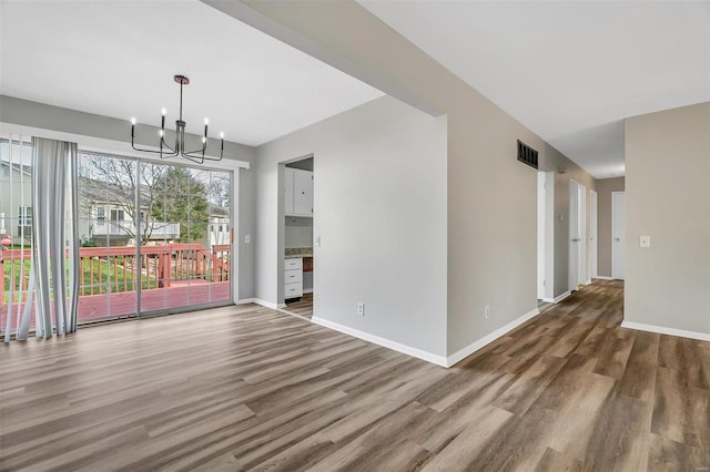 unfurnished dining area with a chandelier and dark hardwood / wood-style floors