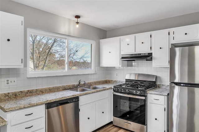 kitchen featuring white cabinets, stainless steel appliances, tasteful backsplash, and sink