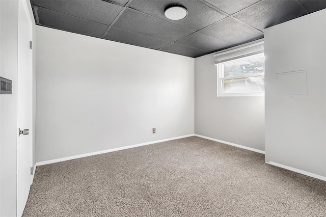 carpeted spare room with a drop ceiling