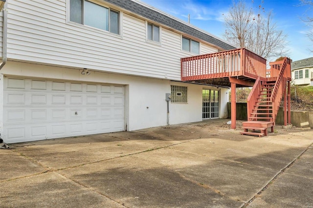 back of house featuring a garage and a deck