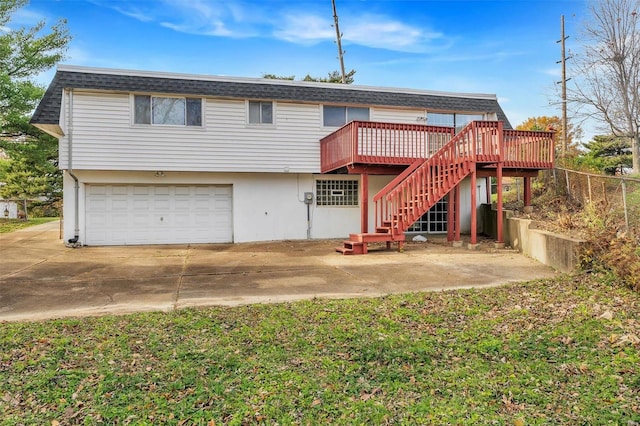 rear view of property with a garage and a deck