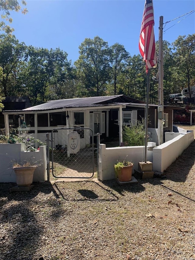 back of house featuring fence and a gate