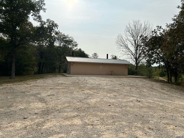 exterior space featuring an outdoor structure and metal roof