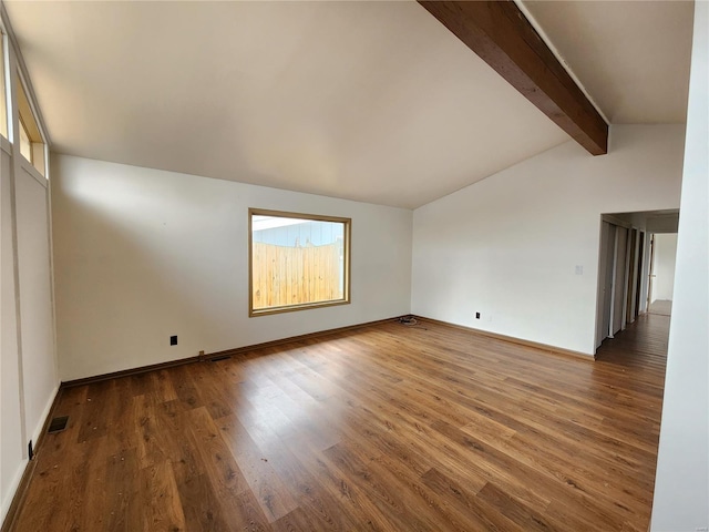 unfurnished room featuring lofted ceiling with beams and wood-type flooring