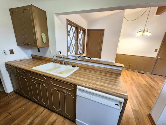 kitchen featuring an inviting chandelier, white dishwasher, sink, hanging light fixtures, and light hardwood / wood-style floors