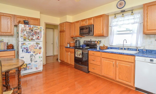 kitchen with light hardwood / wood-style flooring, sink, white appliances, and tasteful backsplash