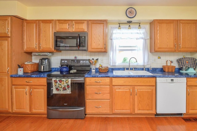 kitchen with white dishwasher, sink, tasteful backsplash, black / electric stove, and light wood-type flooring