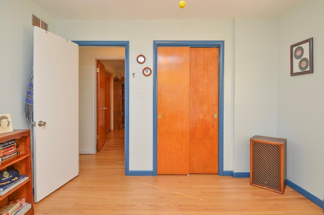 bedroom with light wood-type flooring and a closet