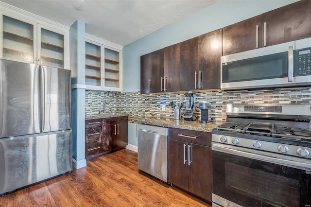 kitchen featuring dark brown cabinets, dark hardwood / wood-style flooring, light stone countertops, and stainless steel appliances