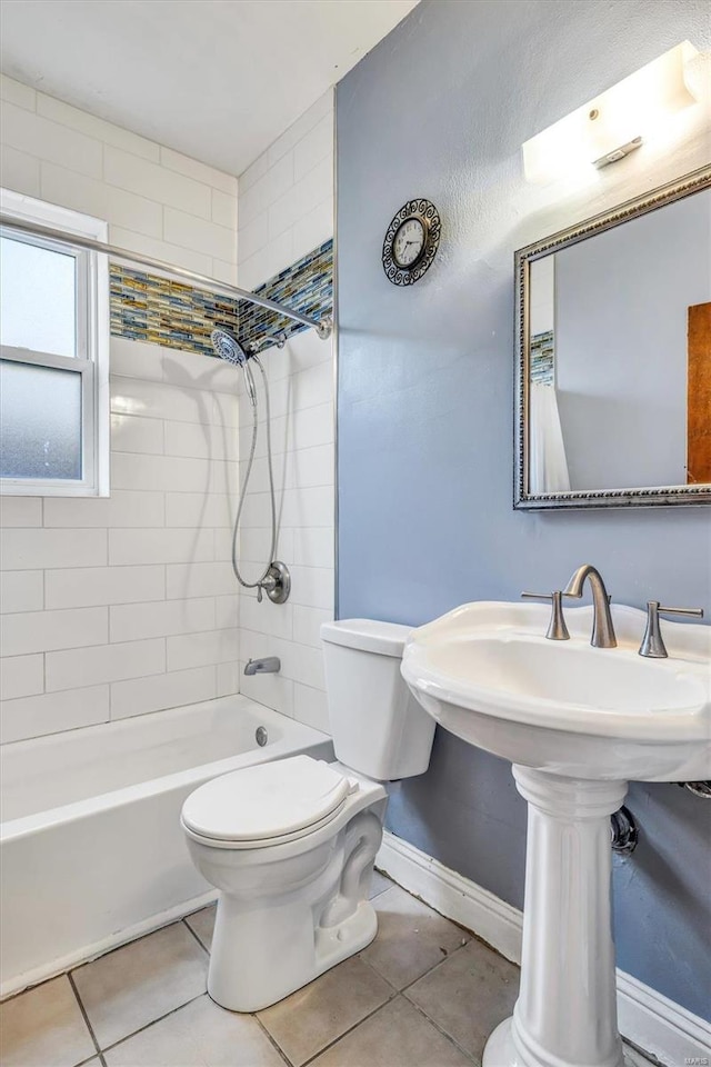 bathroom featuring tile patterned flooring, tiled shower / bath, and toilet