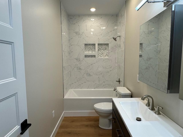 full bathroom featuring hardwood / wood-style floors, vanity, toilet, and tiled shower / bath