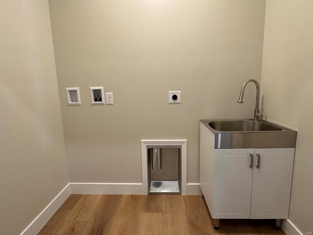 laundry area featuring cabinets, light hardwood / wood-style flooring, hookup for an electric dryer, hookup for a washing machine, and sink