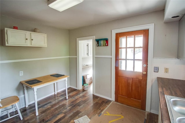 doorway to outside featuring sink and dark hardwood / wood-style floors