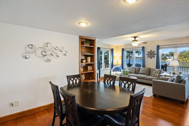 dining area featuring a textured ceiling, dark wood-type flooring, and ceiling fan