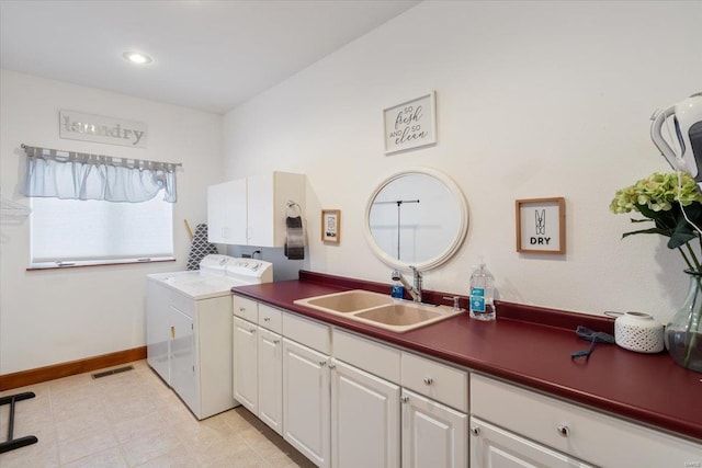 laundry area featuring sink, washer and clothes dryer, and cabinets