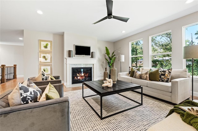 living room featuring light hardwood / wood-style floors, ceiling fan, and a healthy amount of sunlight