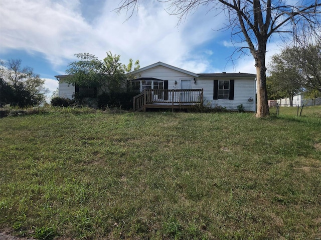 back of house featuring a lawn and a deck