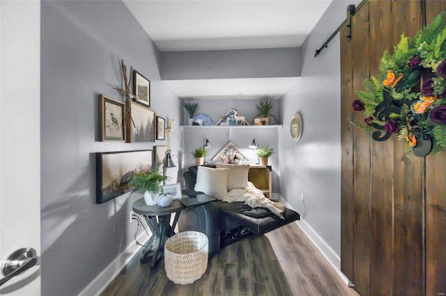 living area with wood-type flooring and a barn door