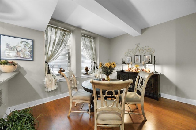 dining area featuring beam ceiling and hardwood / wood-style flooring