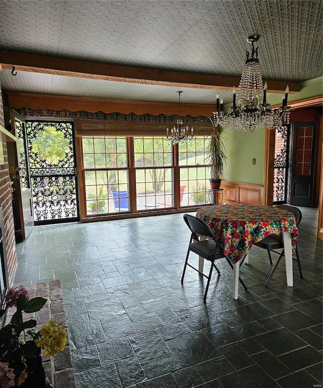 dining area featuring beam ceiling and a notable chandelier