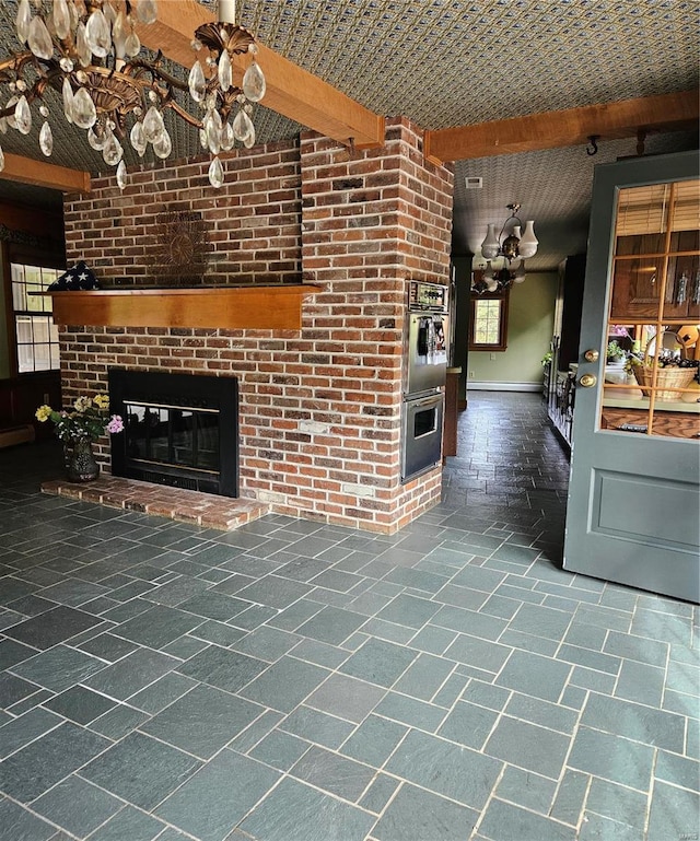 unfurnished living room with a brick fireplace, beamed ceiling, a baseboard heating unit, and a wealth of natural light