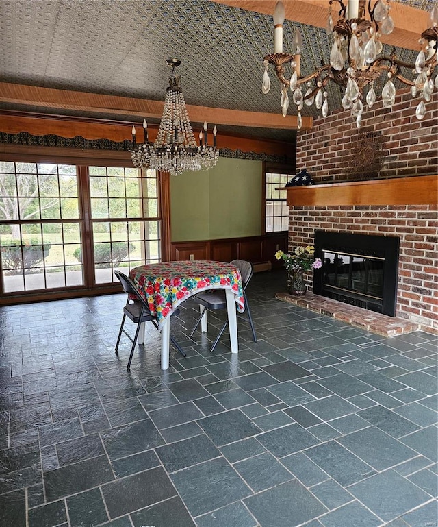 unfurnished dining area featuring a fireplace, wood walls, vaulted ceiling, and a chandelier