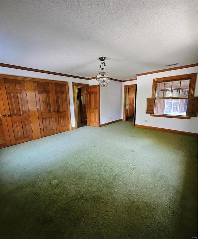 unfurnished living room with carpet, ornamental molding, a chandelier, and a textured ceiling