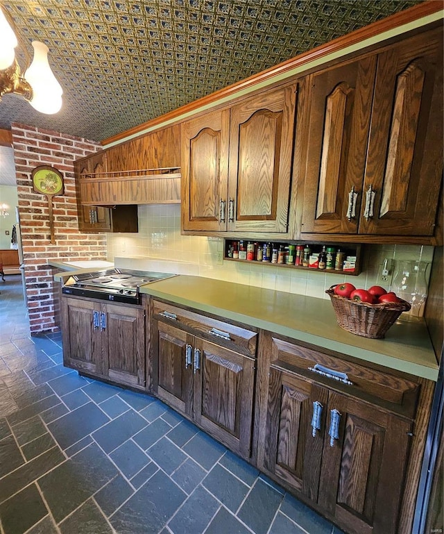 kitchen featuring crown molding, stainless steel gas cooktop, decorative backsplash, and vaulted ceiling