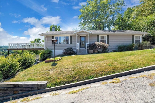 single story home featuring a front yard and a wooden deck