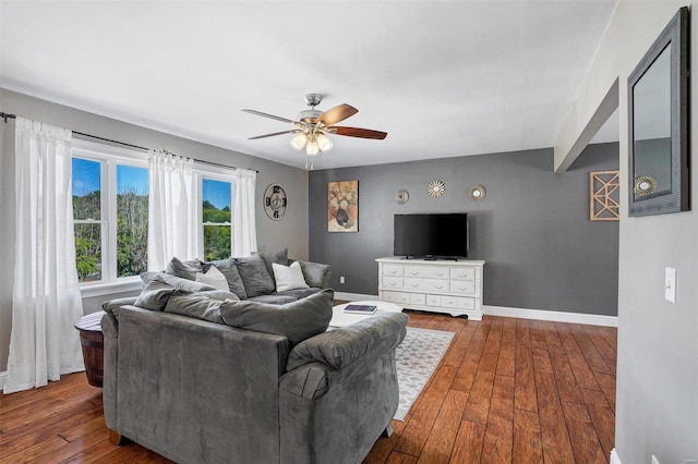 living room featuring dark wood-type flooring and ceiling fan