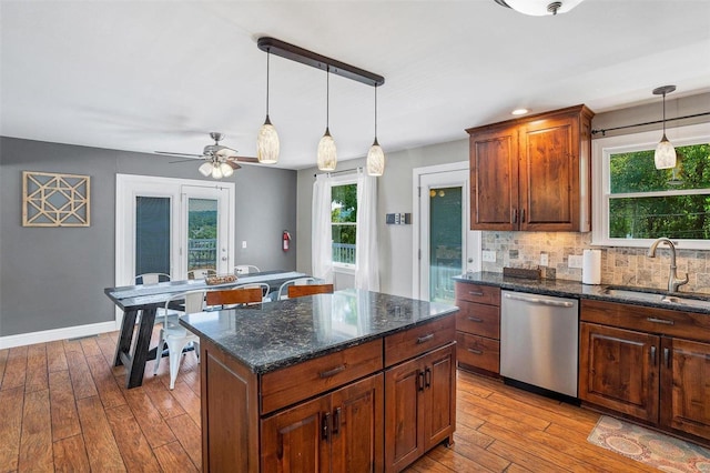 kitchen with a wealth of natural light, sink, dishwasher, and light hardwood / wood-style floors