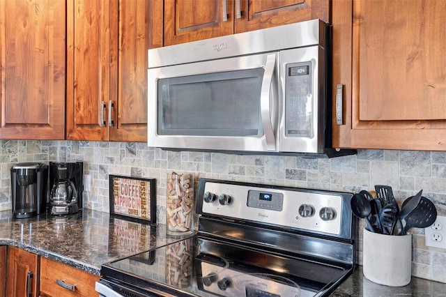 kitchen with dark stone countertops, appliances with stainless steel finishes, and decorative backsplash