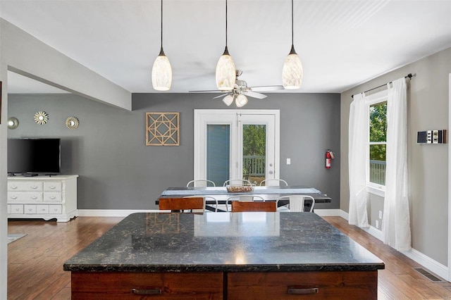 kitchen with a center island, dark wood-type flooring, and pendant lighting