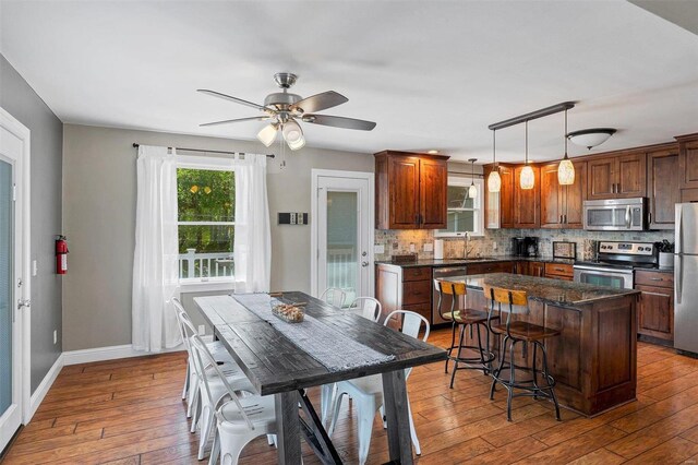 dining room with hardwood / wood-style flooring, sink, and ceiling fan