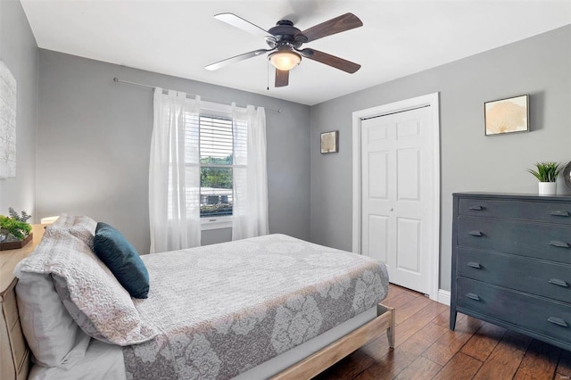 bedroom with a closet, dark wood-type flooring, and ceiling fan