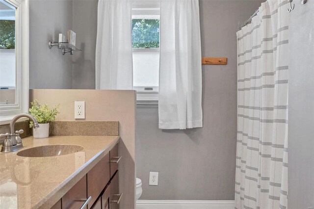 bathroom featuring vanity, toilet, and walk in shower