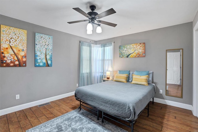 bedroom with dark hardwood / wood-style floors and ceiling fan