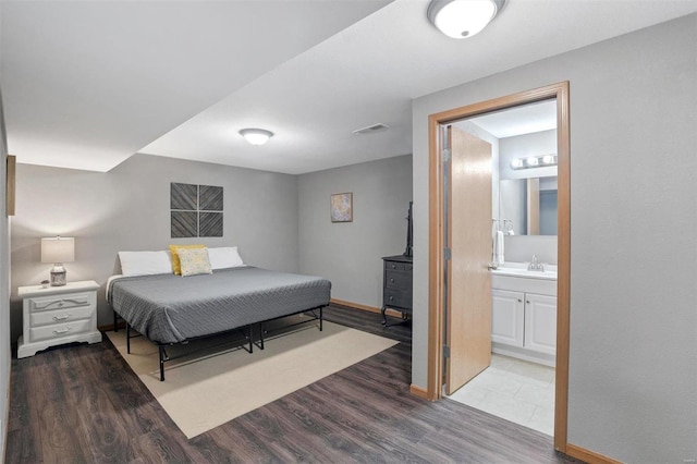 bedroom with connected bathroom, sink, and wood-type flooring