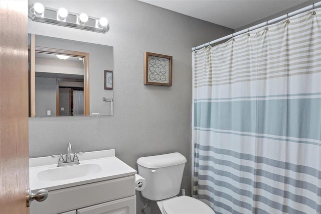 bathroom with toilet, vanity, and a shower with shower curtain