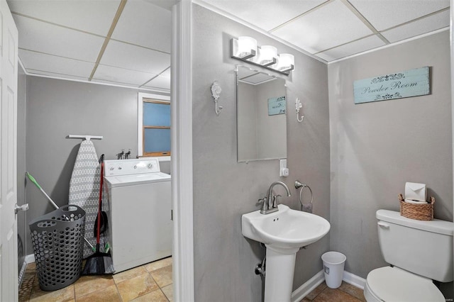 bathroom featuring washer / dryer, a paneled ceiling, tile patterned flooring, and toilet