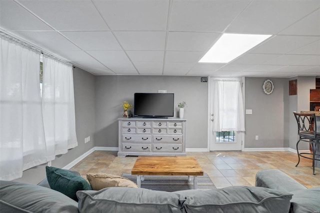 living room with light tile patterned floors and a drop ceiling