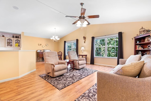 living room with ceiling fan with notable chandelier, light wood-type flooring, and vaulted ceiling